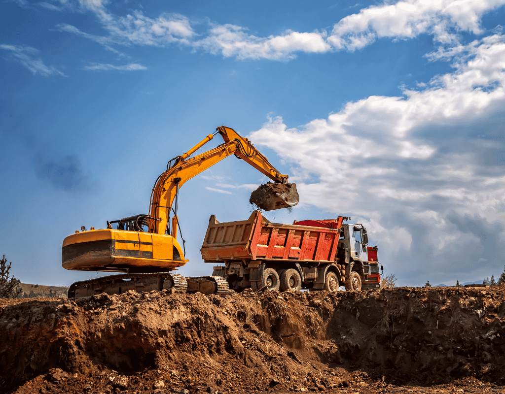 excavator loading dirt into dump truck during excavation project in Wagoner County OK