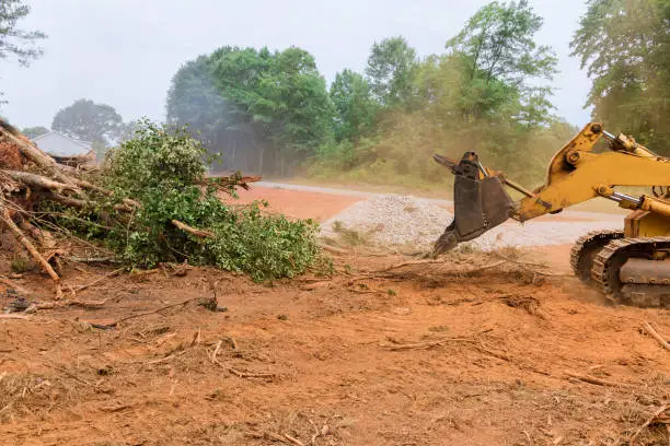 Crew clearing dense brush on Owasso homesite before driveway and pad preparation